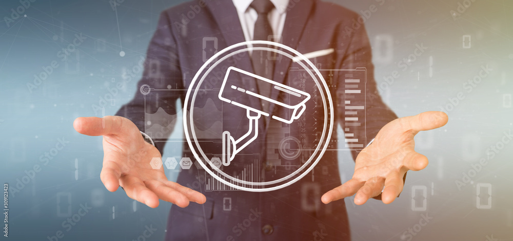 Poster businessman holding security camera system icon and statistics data - 3d rendering