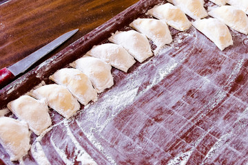 Traditional pelmeni or dumpling at cutting board.