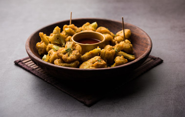 Gobi pakora or Phoolgobi pakoda made using fresh cauliflower dipped chickpea batter and then fried in oil. served with tomato ketchup and mint chutney. selective focus