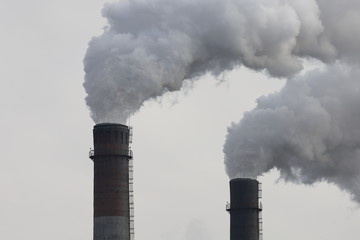 Factory chimneys smoking with dense white smoke. Industrial pollution of air, electric plant emission,  environment ecology problem.