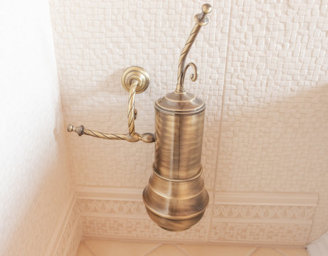 bronze toilet brush hanging on the wall