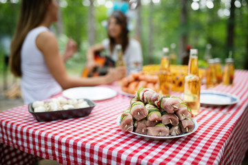 Group of happy friends eating and toasting at garden barbecue