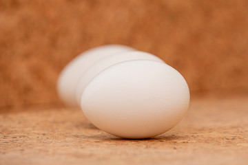 White chicken eggs are on cork. Easter card greeting. Flat lay. Copy space.