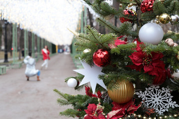 Christmas decorations in a Moscow, happy girls photographing on a street and enjoy the magic of winter holiday. New Year tree with toy balls and stars