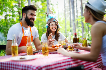 Friends having a barbecue party and fun in nature