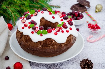 Chocolate cake Christmas wreath with sugar icing, cranberries, pomegranate and mint leaves on top.  Festive Dessert for Christmas and New Year.