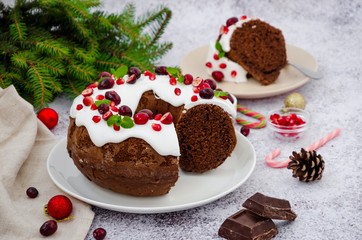 Chocolate cake Christmas wreath with sugar icing, cranberries, pomegranate and mint leaves on top.  Festive Dessert for Christmas and New Year.