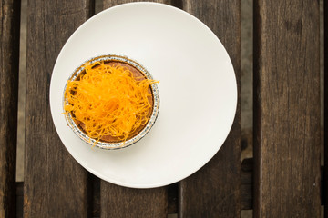 Cup cake decoration by yolk threads on white plate. Fusion dessert between international and thai cuisine.
