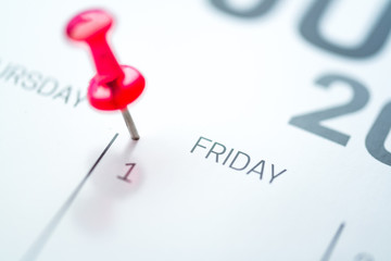 Red push pin on calendar 1st day of the month