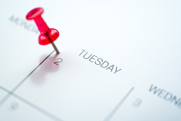 Red push pin on calendar 2nd day of the month