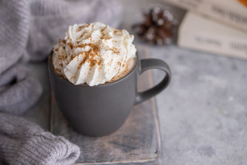 Cozy home concept. Mug of hot chocolate , candle, book and wool sweater.  Winter relax mood and hygge background.