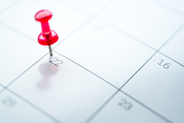 Red push pin on calendar 22nd day of the month