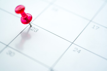Red push pin on calendar 23rd day of the month