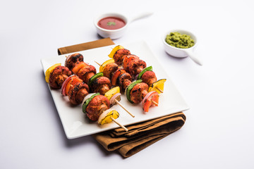 Barbecue or tandoori Mushroom Tikka, served in a plate with green chutney and ketchup. selective focus