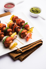 Barbecue or tandoori Mushroom Tikka, served in a plate with green chutney and ketchup. selective focus