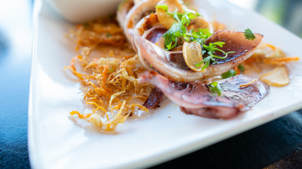 grilled squid with seafood sauce on plate.