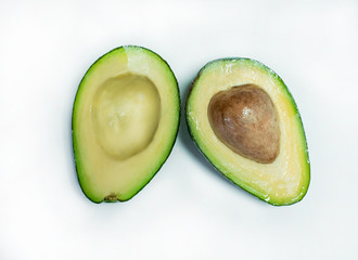 isolated avocado on a dark wood and white background. selective focus