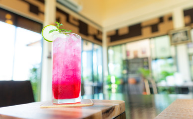 Soda Red sparkling water with ice in a glass on table,lunch time.