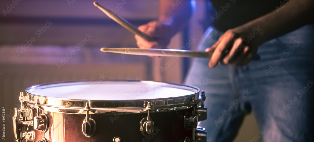 Wall mural man playing the snare drum on a beautiful colored background