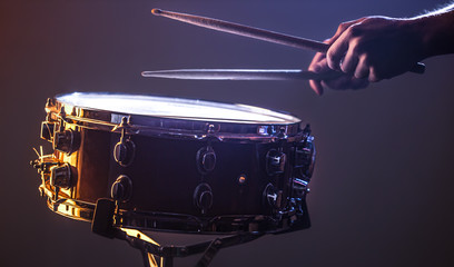 man playing the snare drum on a beautiful colored background