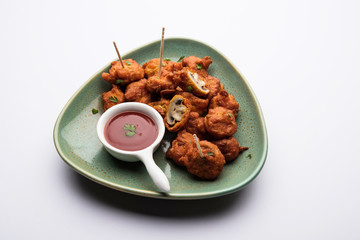 Mushroom 65, starter or appetiser food recipe from India. served in a plate with ketchup. selective focus