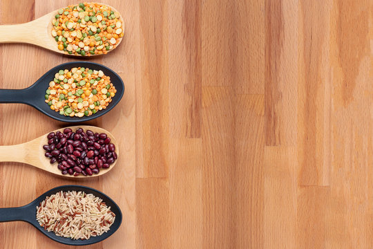 Bean grains in tablespoons on a wooden background. Natural healthy eating concept