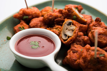 Mushroom 65, starter or appetiser food recipe from India. served in a plate with ketchup. selective...