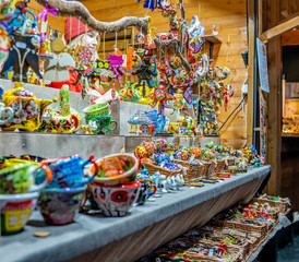 A young lady selling homemade Christmas toys and gifts at the 2019 Christmas market in Aachen, Germany