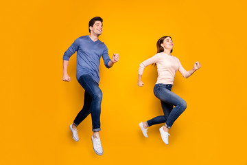 Fototapeta na wymiar Full length photo of cheerful couple jump run fast after summer time sales discounts wear pink blue sweater isolated over shine color background
