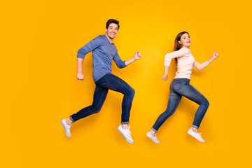 Fototapeta na wymiar Full body profile side photo of funky brown red hair married couple jump run after sales discounts wear pink blue sweater sneakers isolated over yellow color background