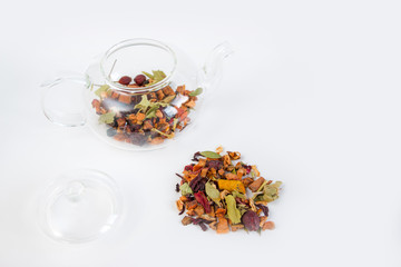 Fruit tea (tea leaves) in a glass teapot on a white background. Breakfast and tea party concept.