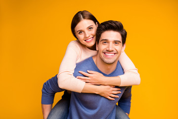 Portrait of charming two married people man piggy-back his sweetheart enjoy passionate dating wear casual style clothing isolated over shine color background