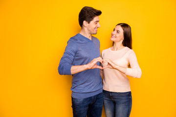 Love forever concept. Tender passionate two people spouses hug embrace make heart finger look feel support wear modern outfit denim jeans isolated over yellow color background