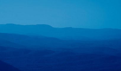 low mountains in mist colored in trendy Classic Blue color of the year 2020