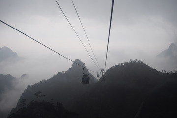 Cable cars bypassing hills in cloudy day