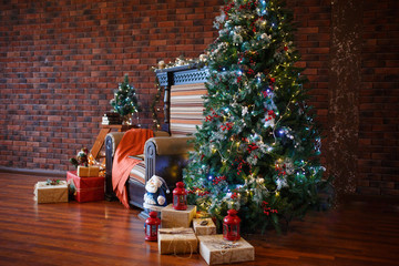Decorated for The new year Interior of the house. Christmas tree and decorated Studio, garlands of lights, decorations, gift boxes in a cozy home, a large armchair and a fireplace.