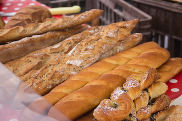 Fresh bread on outdoor market. Homemade baguettes on farmers market. Fresh bakery products. Traditional market day in France. Delicious healthy food. Wheat baked products. Gluten free baguette.