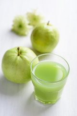 Green guava fruit and guava juice in glass on white background, high vitamin C healthy drink