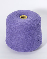 Green bobbin of yarn on a white background.Textile reel on isolated white background.