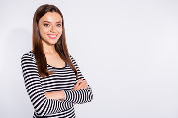 Fototapeta premium Turned portrait of lovely woman crossing her hands looking at camera with toothy smile wearing striped pullover isolated over white background