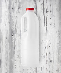 Plastikowa biała butelka na tle z białych desek
