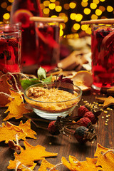 Christmas mulled wine or gluhwein with spices, chocolate candies, sweets and orange slices on rustic table, traditional drink on winter holiday, christmas lights and decorations