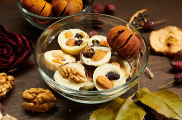 Homemade chocolate candies on rustic table, decorated with dry fruits, rose flower and walnut