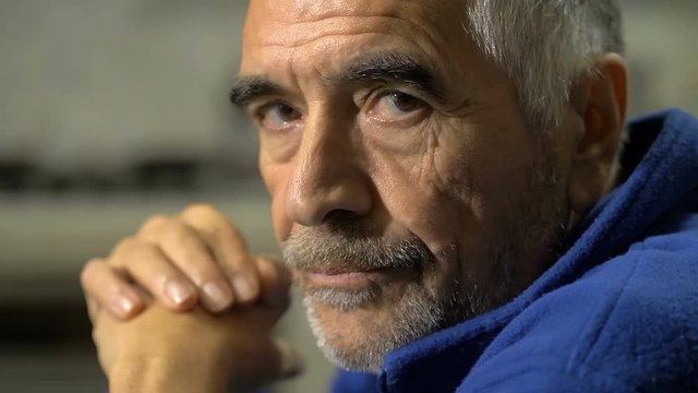 profile of thoughtful mature man turning his head and looking at camera