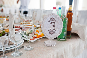 Beautiful wedding set decoration in the restaurant. Number 3 on table.