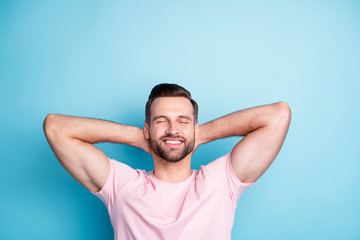 Photo of attractive guy holding hands behind head eyes closed enjoy amazing weekend day relaxing wear casual pink t-shirt isolated blue color background