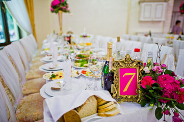 Beautiful wedding set decoration in the restaurant. Number 7 on table.