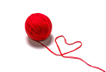 wool skein red thread in the shape of heart on white background