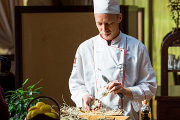 chef opens fresh oyster in a restaurant