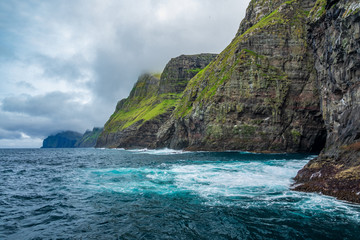 Fototapeta na wymiar Steep coastline of Faroe islands with spectacular cliffs